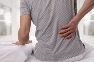 closeup of a man holding his back in pain