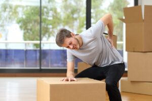 man with lower back pain because of lifting a box