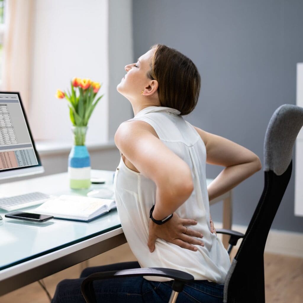 Person sitting at desk stretching back